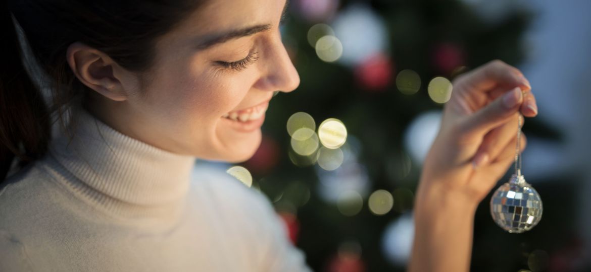 front-view-young-woman-decorating-tree-with-globe